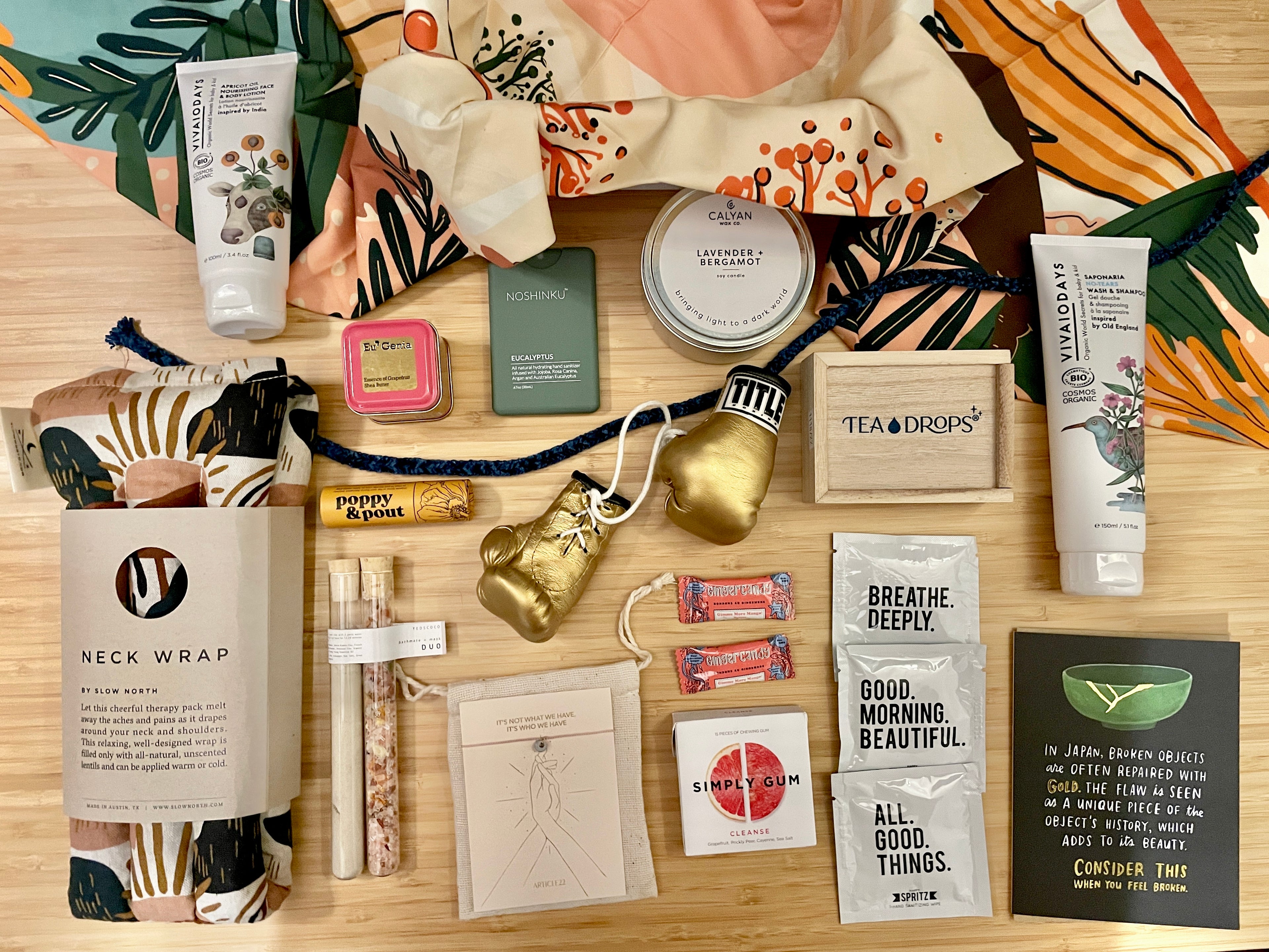 flatlay of cancer comfort care box contents beauty and wellness products in neutral color tones 